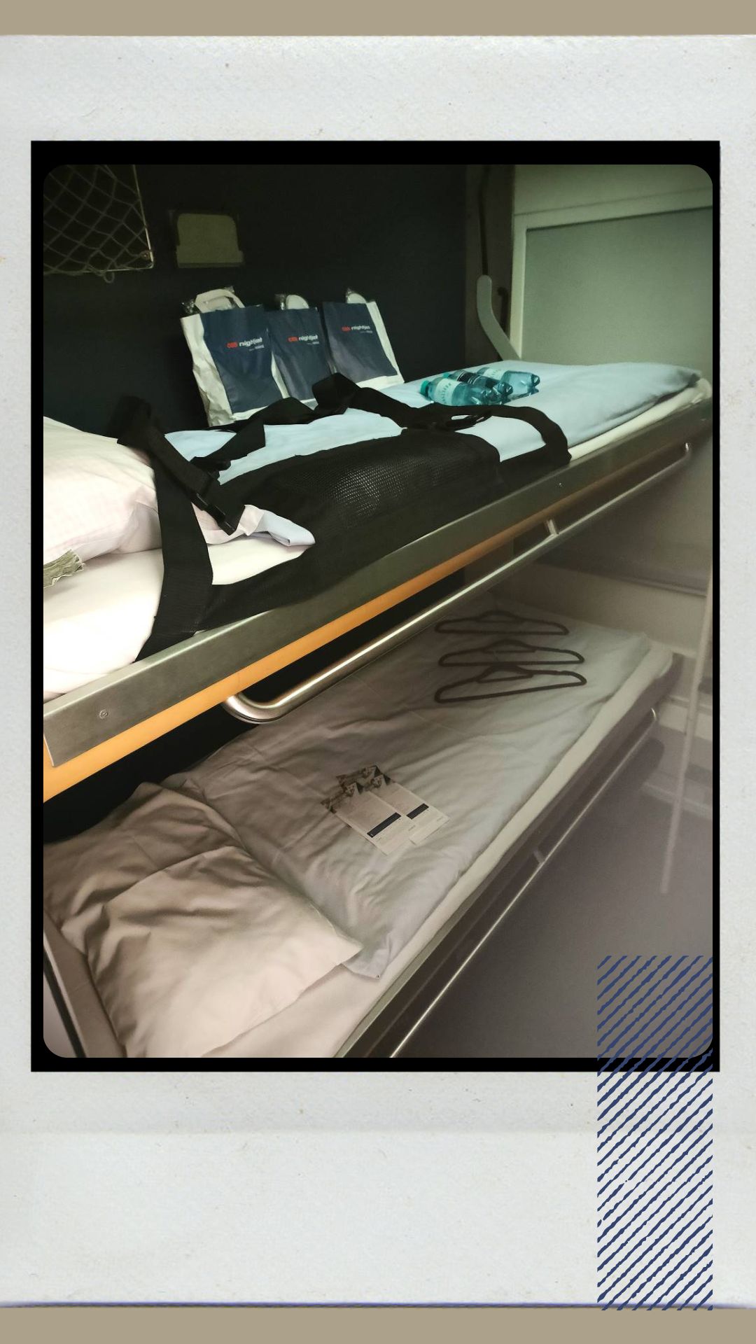 Two bunk beads are made up with clean white sheets. On the beds are welcome bags, menus and coat-hangers